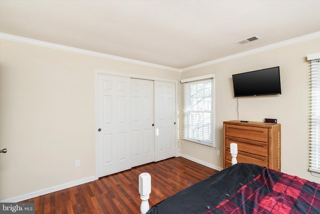 bedroom with crown molding, dark wood-type flooring, and a closet