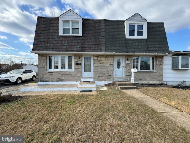 cape cod home featuring a front yard