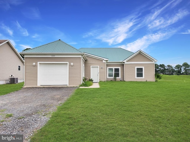 view of front of home with cooling unit, a garage, and a front lawn