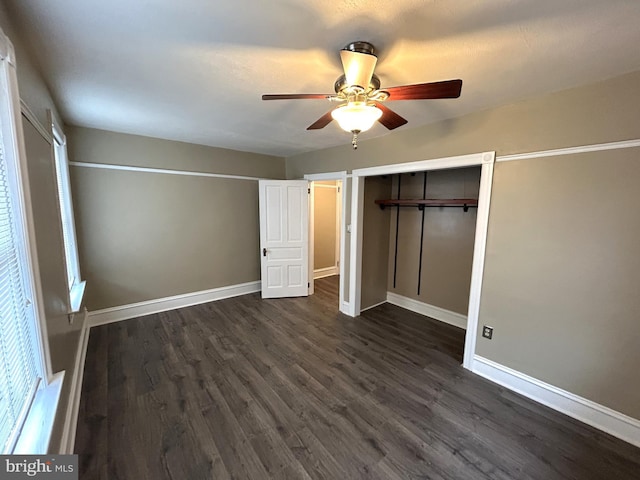 unfurnished bedroom with dark wood-type flooring, ceiling fan, and a closet