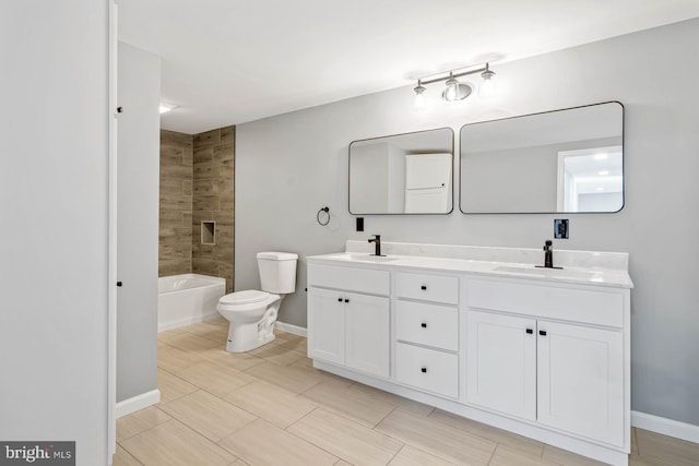 full bathroom featuring tiled shower / bath combo, vanity, and toilet