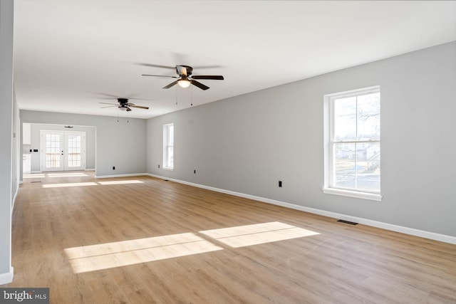 unfurnished room with plenty of natural light, french doors, and light wood-type flooring