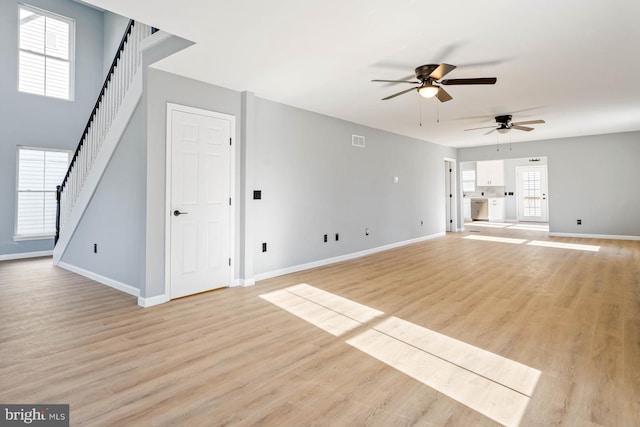 unfurnished living room featuring ceiling fan and light wood-type flooring