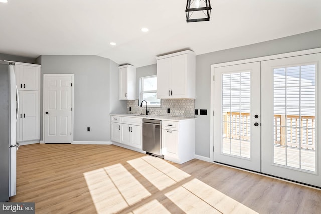 kitchen with sink, white cabinetry, backsplash, stainless steel appliances, and french doors