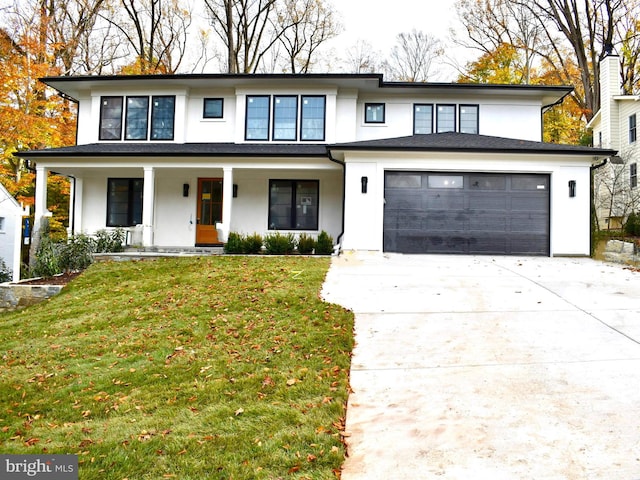 prairie-style house with a garage, covered porch, and a front lawn