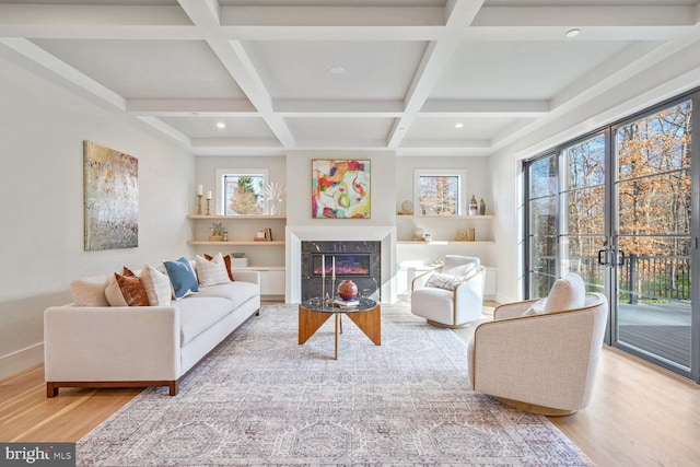 living room with hardwood / wood-style flooring, a premium fireplace, coffered ceiling, and beamed ceiling