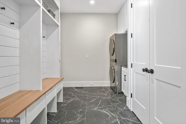 mudroom featuring stacked washer and clothes dryer