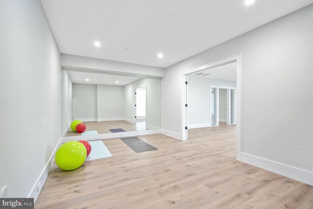 exercise room with light hardwood / wood-style flooring