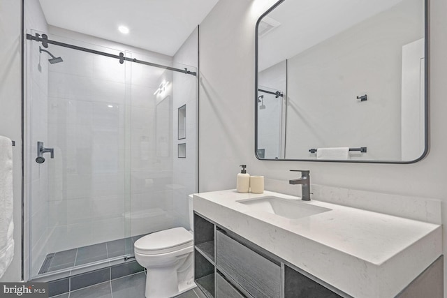 bathroom with vanity, tile patterned floors, a shower with door, and toilet