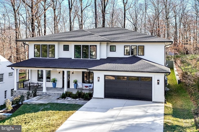 view of front of home with a garage, a front yard, and covered porch