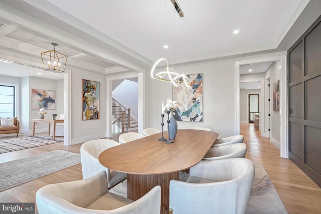 dining room with light wood-type flooring and a notable chandelier