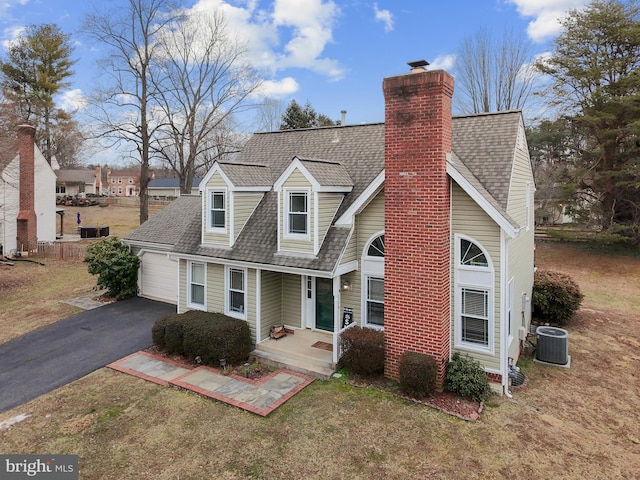 cape cod home featuring central AC, a garage, and a front yard