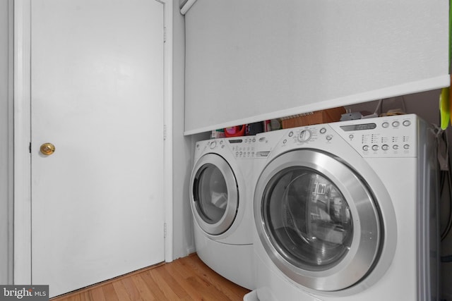 laundry area featuring light hardwood / wood-style flooring and washing machine and dryer