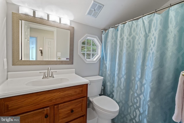 bathroom featuring walk in shower, vanity, and toilet