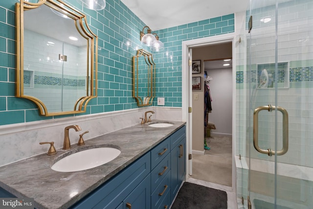 bathroom with tile walls, vanity, tile patterned floors, and walk in shower