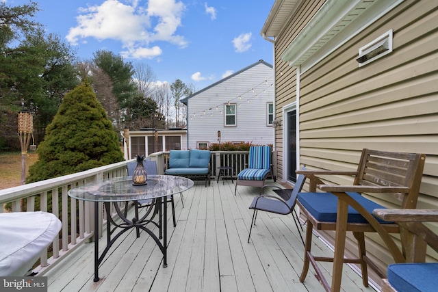 wooden terrace with an outdoor living space