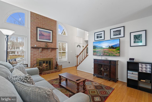 living room featuring a brick fireplace and light hardwood / wood-style flooring