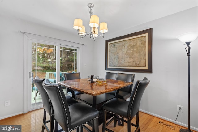 dining room with an inviting chandelier and light hardwood / wood-style flooring