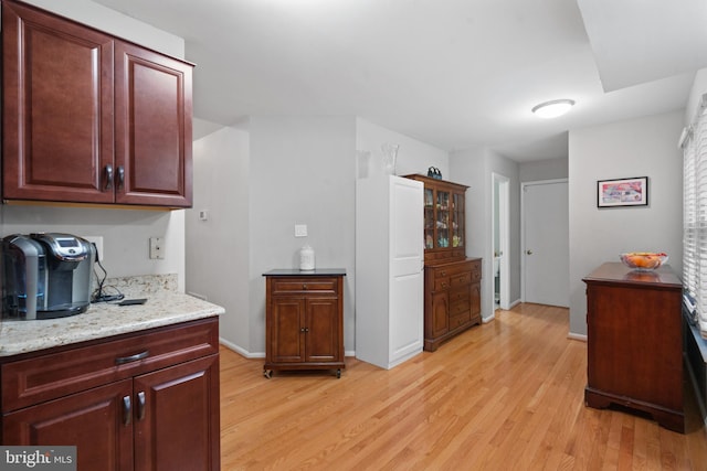 kitchen featuring light stone countertops and light hardwood / wood-style floors