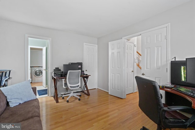 office area with washer / clothes dryer and light wood-type flooring