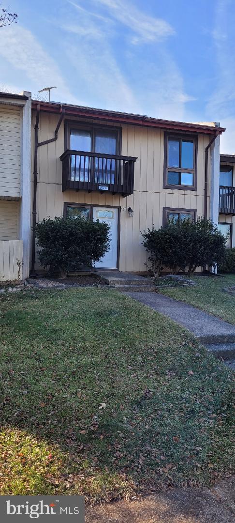 view of front facade featuring a front yard and a balcony