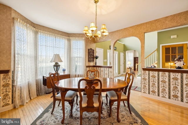 dining space featuring hardwood / wood-style floors and a chandelier