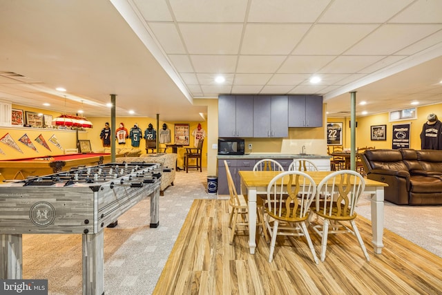 game room with sink, a paneled ceiling, and light colored carpet