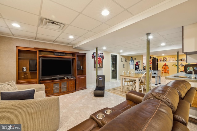 carpeted living room with a drop ceiling