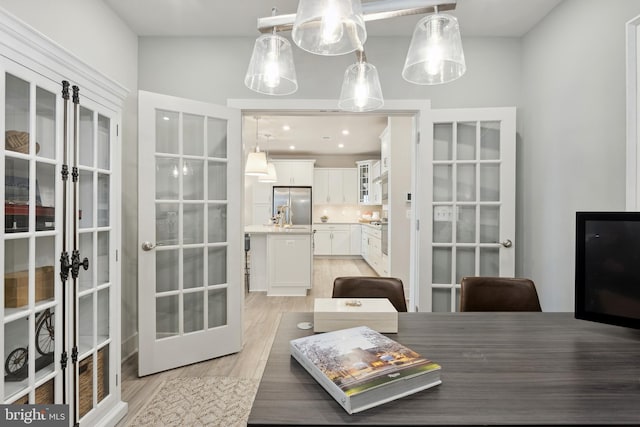 dining area featuring french doors and light hardwood / wood-style floors