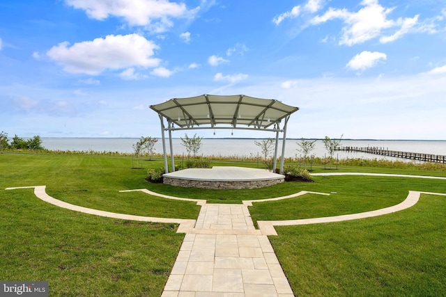 view of home's community with a water view and a lawn