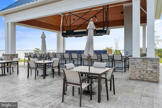 view of patio featuring a bar, a gazebo, and a water view