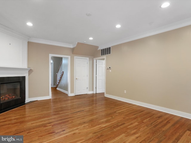 unfurnished living room featuring crown molding, hardwood / wood-style floors, and a fireplace