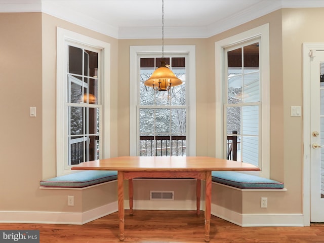 unfurnished dining area featuring hardwood / wood-style flooring, ornamental molding, and breakfast area