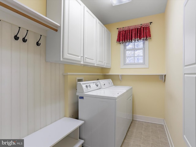 clothes washing area with cabinets and washing machine and dryer