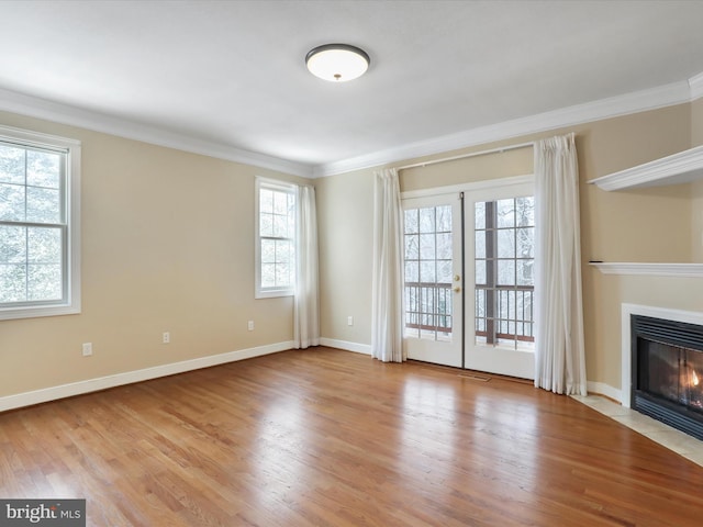 unfurnished living room with french doors, ornamental molding, and light hardwood / wood-style flooring