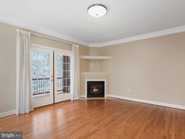 unfurnished living room with crown molding, light hardwood / wood-style floors, and french doors