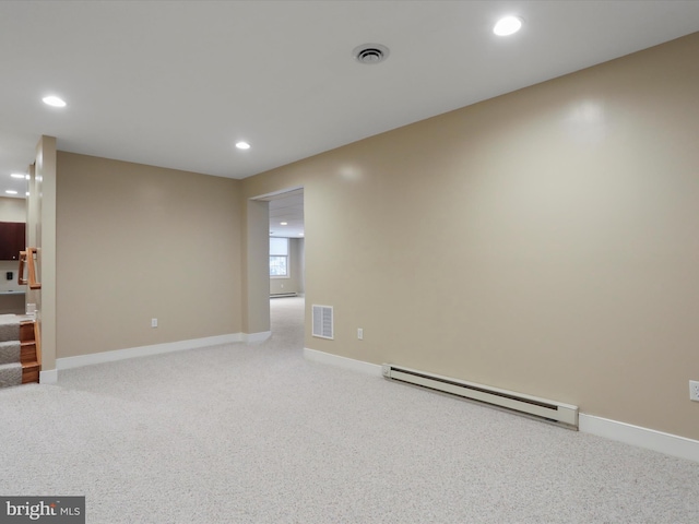 spare room with light colored carpet and a baseboard heating unit