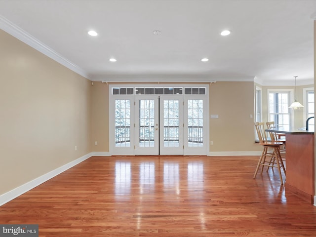 interior space with ornamental molding and light hardwood / wood-style flooring