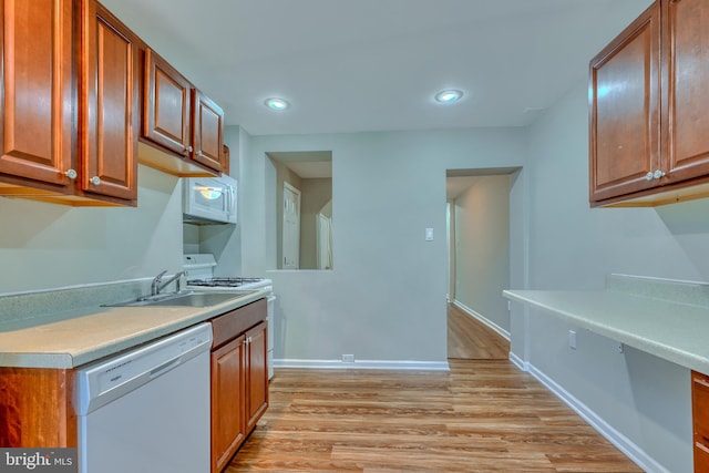 kitchen featuring sink, white appliances, and light hardwood / wood-style floors