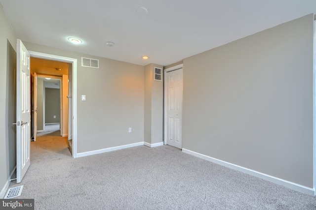 unfurnished bedroom featuring a closet and light carpet