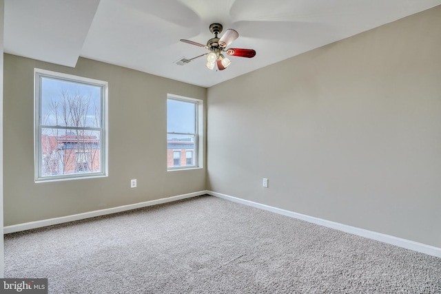 spare room with ceiling fan and carpet