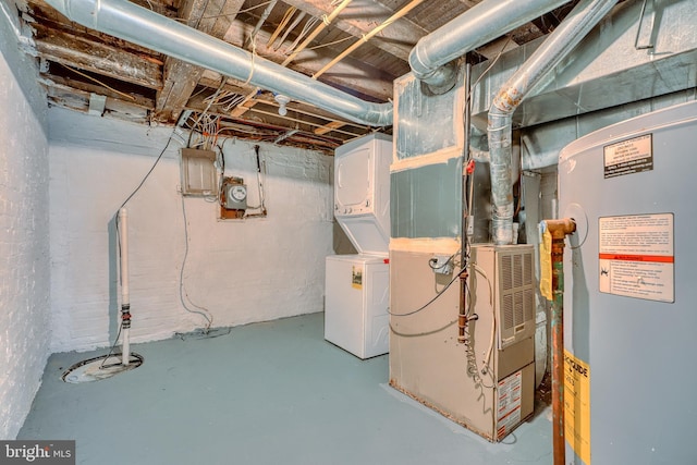 basement with heating unit, water heater, stacked washer and clothes dryer, and electric panel