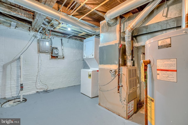 basement with stacked washer and clothes dryer, electric panel, and water heater