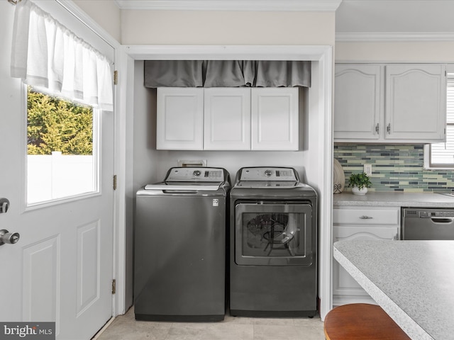 clothes washing area with crown molding and separate washer and dryer