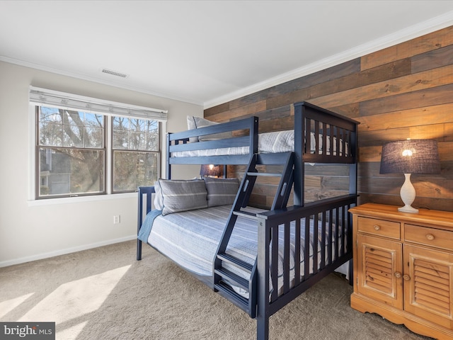 bedroom featuring ornamental molding, wood walls, and carpet