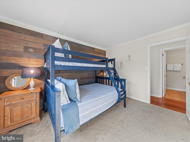 carpeted bedroom with crown molding and wood walls