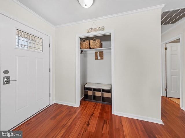 entrance foyer with ornamental molding and dark hardwood / wood-style flooring