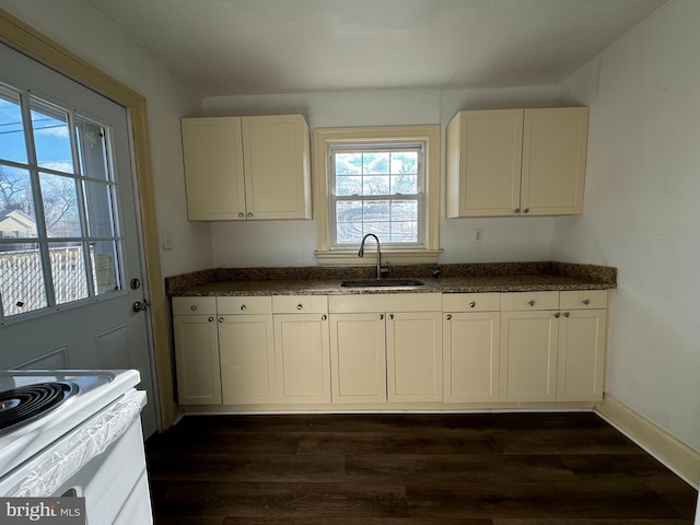 kitchen featuring sink, white cabinetry, dark stone countertops, white electric stove, and dark hardwood / wood-style floors