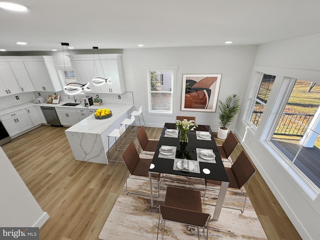 dining space with sink and light wood-type flooring