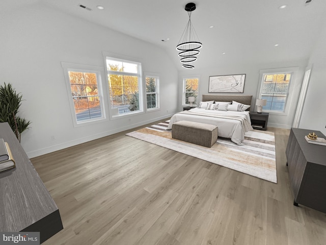 bedroom featuring an inviting chandelier and light hardwood / wood-style floors